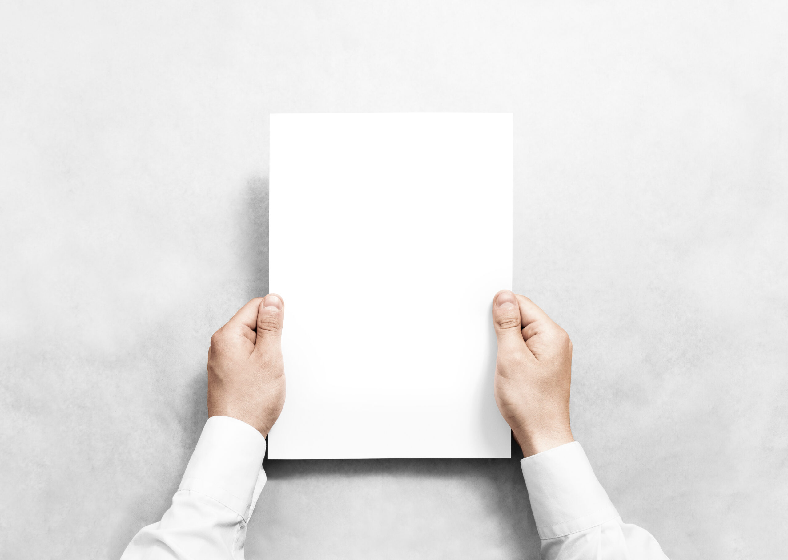Blank Document in Hands – A person in white sleeves holds a completely blank sheet of paper in front of a gray background.
